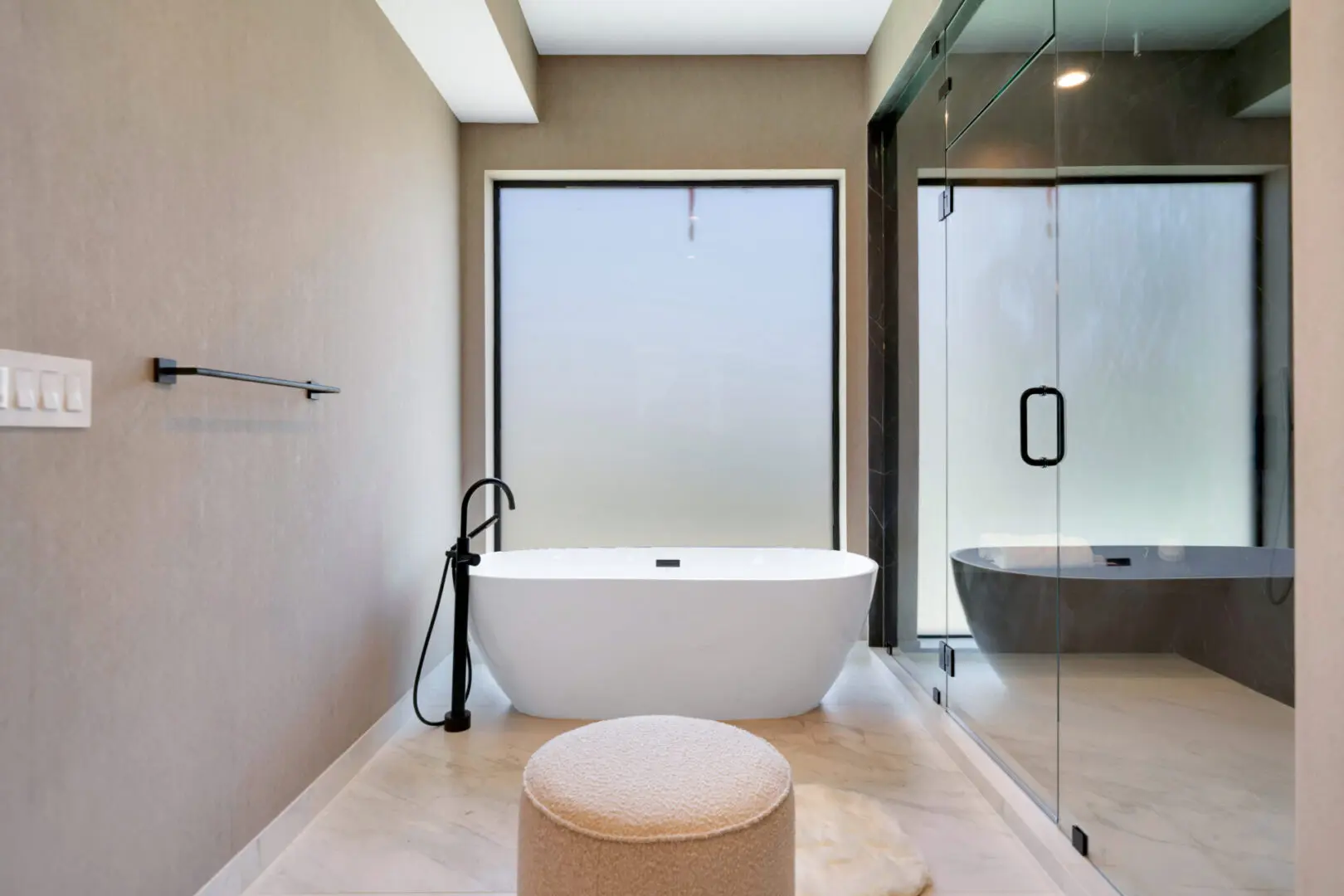 A bath tub and the matte black colored shower fixture