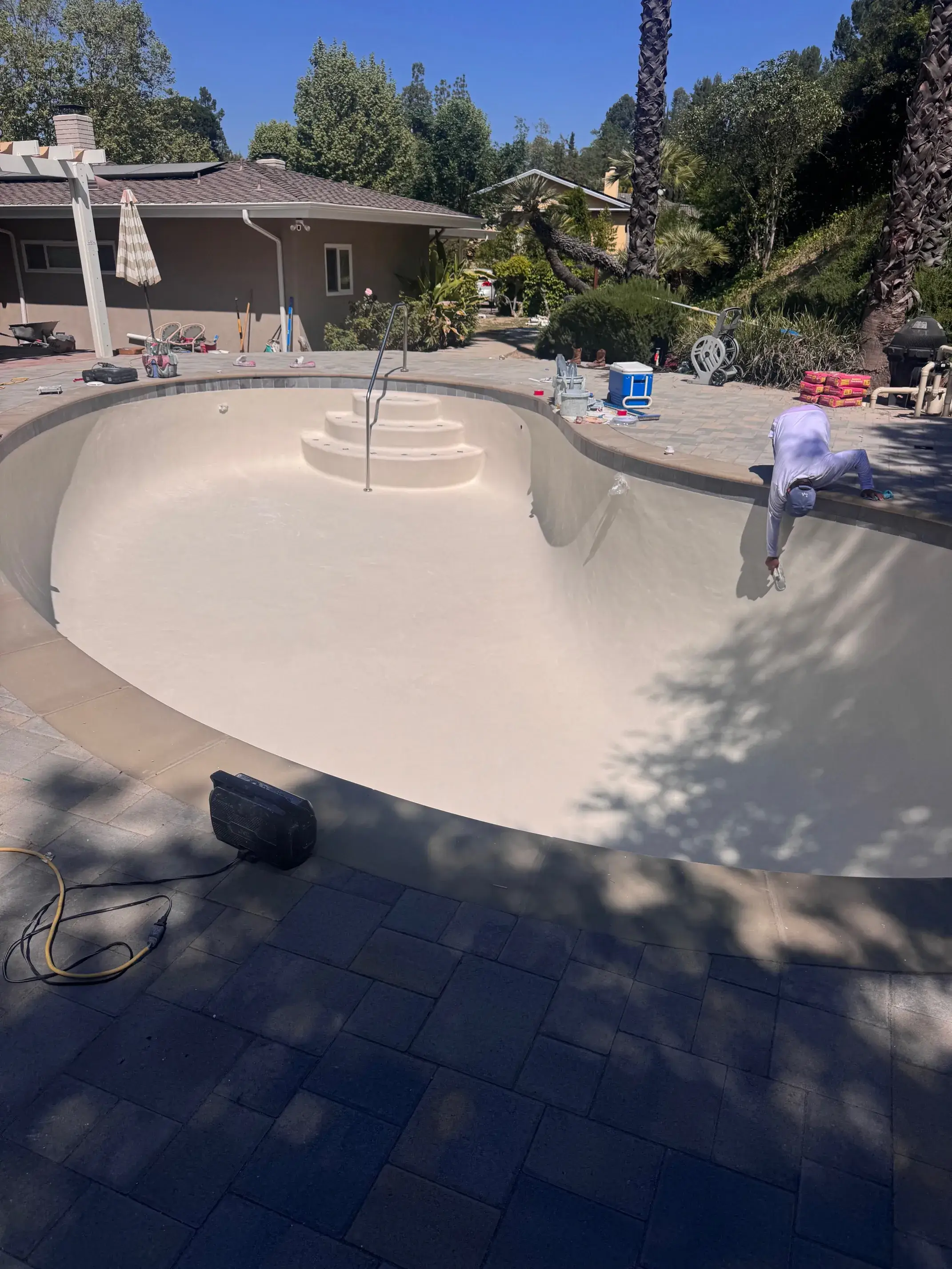 Backyard pool being cleaned